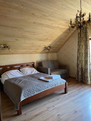 um quarto com uma cama e um sofá num quarto em Вiлла Тераса em Polyana