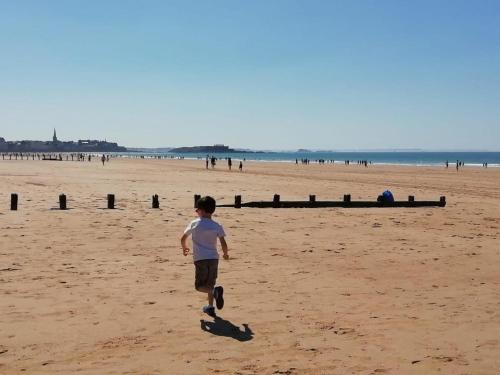 Un joven caminando por la playa en Alba hotel, en Saint-Malo