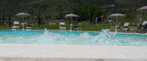 - une piscine d'eau avec des chaises et des parasols dans l'établissement Il Sentiero di Leano, à Terracine