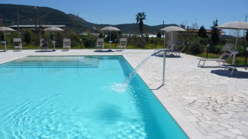 une grande piscine avec des chaises et des parasols dans l'établissement Il Sentiero di Leano, à Terracine