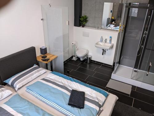 a small bathroom with a bed and a sink at Business-Motel, free XL-Parking, WiFi, massage-chairs, sauna, shared kitchen, breakfast 2go, free soda, coffee in Heimsheim