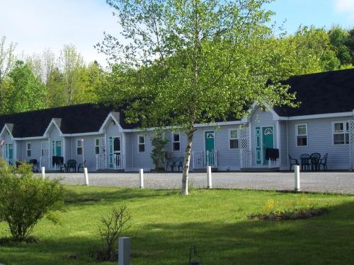 a row of white houses with green doors at Homeport Motel in Lunenburg