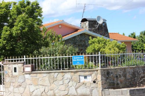 una casa dietro una recinzione con un cartello blu sopra di Quinta de São Marcos a Fundão