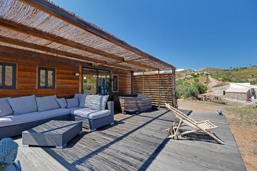 un patio con sofá y sillas en una terraza de madera en Portugals Infinity - Fantástica casa de campo com vista de mar em Tavira, en Tavira