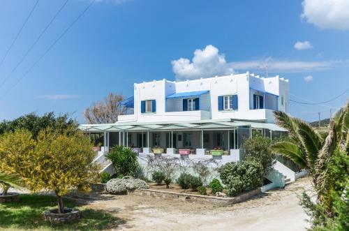 une maison blanche avec des arbres devant elle dans l'établissement Psili Ammos Studios, à Plage d'Aliko