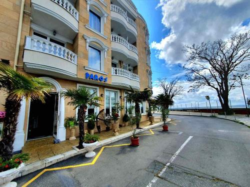 un grande edificio con palme in un parcheggio di Family Hotel Paros a Pomorie