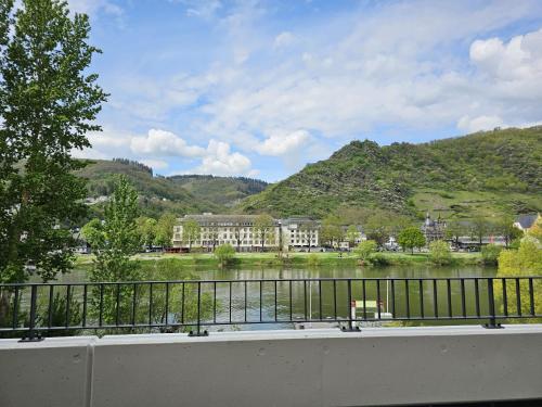 a balcony with a view of a river and buildings at Moselblick II ad Reichsburg Parkplatz 100m Marktplatz in Cochem