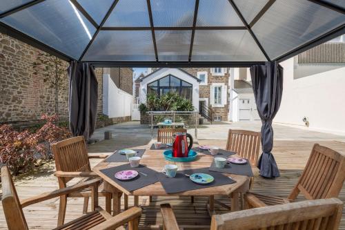 patio con mesa y sillas en una carpa en Villa Sainte Geneviève, en Saint-Malo