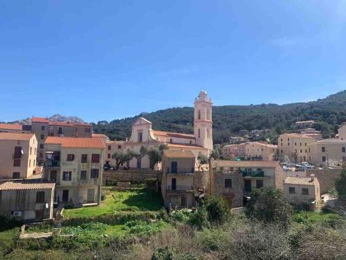 un grupo de edificios en una colina con una torre de reloj en Appartement de standing piana, en Piana