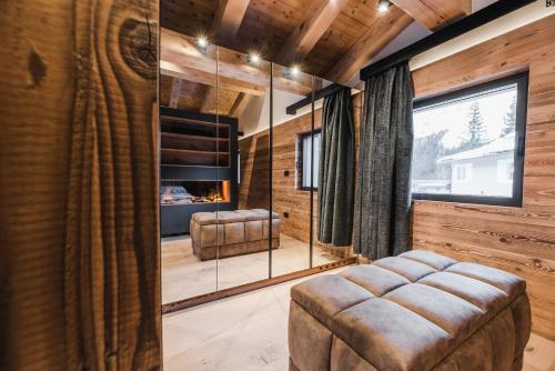 een woonkamer met houten lambrisering en een groot raam bij Chalet Queen in Canazei