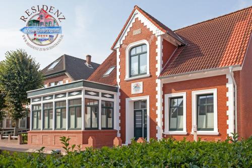 un bâtiment avec un panneau devant lui dans l'établissement Swantje in Residenz zum Südstrand, à Borkum