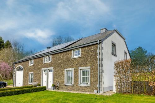 uma casa de tijolos com um telhado de gambrel em Gîte Le Haut des Vannes em Neufchâteau