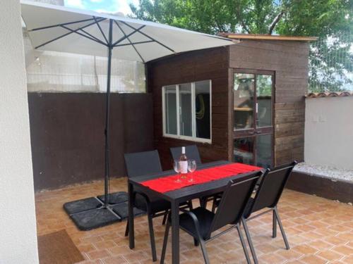 a table and chairs with an umbrella on a patio at Nossa Casa - 2 Bedroom Apartment in Alvor in Alvor