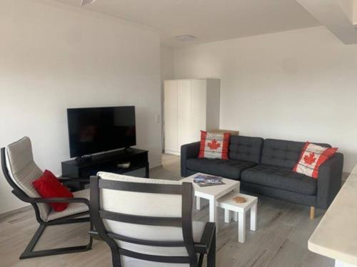 a living room with a couch and a tv at Nossa Casa - 2 Bedroom Apartment in Alvor in Alvor