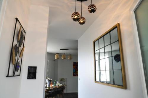 a hallway with a mirror and a dining room at Très Belle MAISON à Rennes St Jacques in Saint-Jacques-de-la-Lande