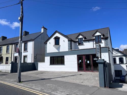 a white building on the corner of a street at Feeney's Audubon Lodge in Galway