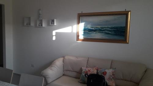 - un salon avec un canapé et une photo sur le mur dans l'établissement Casa sole e luna, à Porto Cesareo