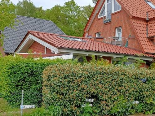 Moderne Ferienwohnung mit Kamin u Garten im EG 100qm Nähe Weser und Golfplatz في آخيم: منزل من الطوب الأحمر مع تحوط أمامه