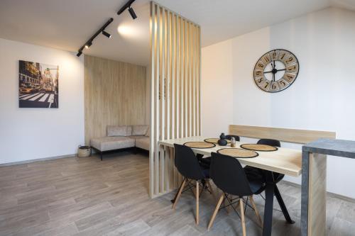 une salle à manger avec une table et une horloge murale dans l'établissement Apartmány Na Lánech, à Litomyšl