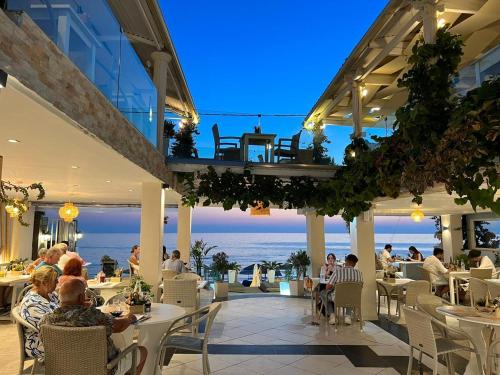 un restaurante con vistas al océano por la noche en Romantic Palace Beach Apartments, en Agios Gordios