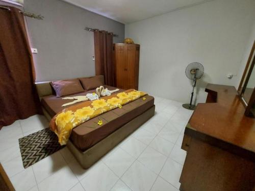 a bedroom with a bed with yellow flowers on it at Justice Seaview Apartment in Le Morne