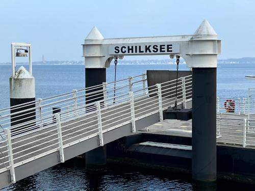 een brug over het water met een bord dat stillsea leest bij Ferienwohnung 1 Zimmer App Ankerplatz 43 im Olympiazentrum in Kiel