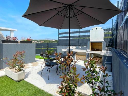 une terrasse avec un parasol, une table et des chaises dans l'établissement Villa Fortuna, à Podstrana