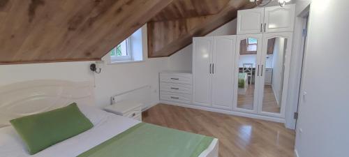 a white bedroom with a bed and a bathroom at Апартаменти - Історія з вікна in Kamianets-Podilskyi