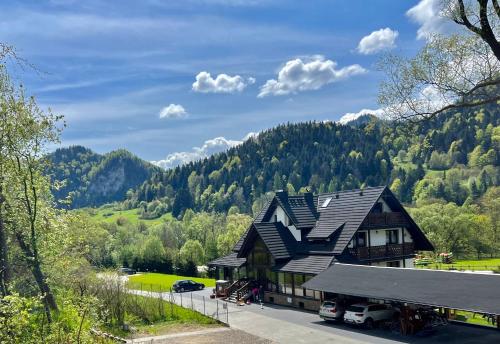 una casa con techo negro y montaña en Willa FOLK Pieniny, en Szczawnica