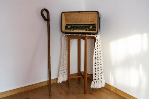 une ancienne radio assise sur un stand à côté d'un mur dans l'établissement Além Tejo Guesthouse, à Mértola