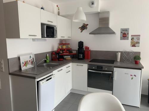 - une cuisine avec des placards blancs et un évier dans l'établissement Charmante maisonnette à Quend Plage, 2 chambres, jardinet, parking, proche commodités - FR-1-482-45, à Quend