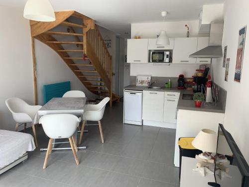 - une cuisine et une salle à manger avec une table et des chaises dans l'établissement Charmante maisonnette à Quend Plage, 2 chambres, jardinet, parking, proche commodités - FR-1-482-45, à Quend