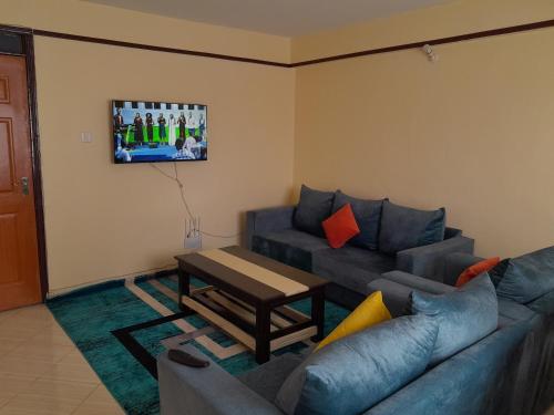 uma sala de estar com um sofá e uma mesa em Milimani Nanyuki em Nanyuki