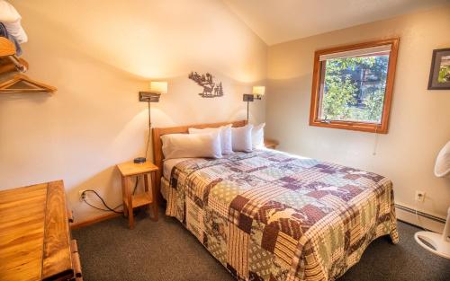 a small bedroom with a bed and a window at McGregor Mountain Lodge in Estes Park