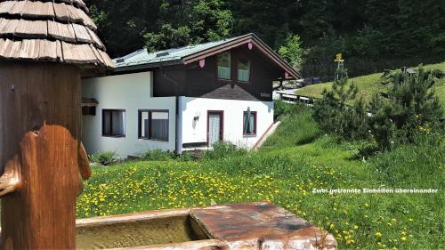 ein Haus mit einem Blumenfeld davor in der Unterkunft Ferienhaus hoch oben mit Alpen Panorama Königssee- Nichtraucherdomizil in Berchtesgaden