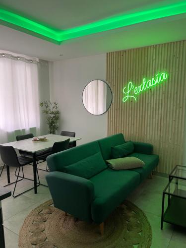 een woonkamer met een groene bank en een tafel bij L'extasia appartement,spa jacuzzi Grenoble in Grenoble