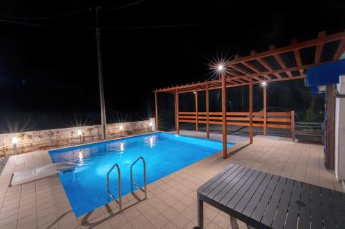 einen Pool in der Nacht mit einem Tisch und einer Bank in der Unterkunft private house noko in Miyako-jima