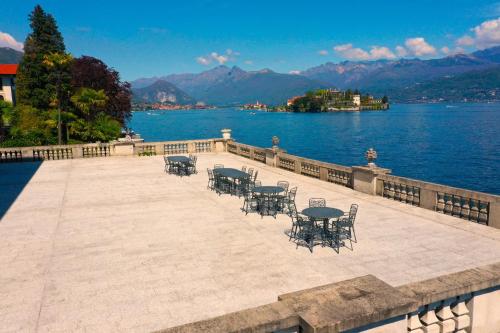 un patio con mesas y sillas junto al agua en Wonderful Stresa apartment, en Stresa