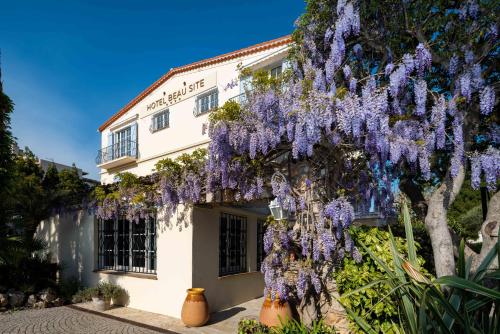 een gebouw met een blauweregen ervoor bij Hôtel Beau Site - Cap d'Antibes in Antibes