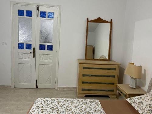 - une chambre avec un miroir, un lit et une commode dans l'établissement Dar Lilia Monastir, à Monastir