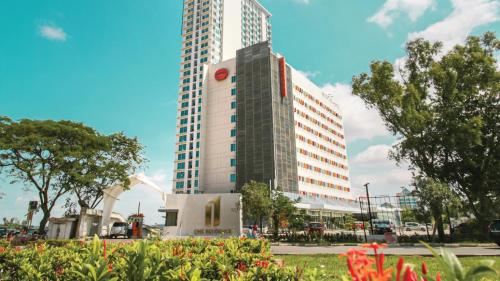 un edificio alto frente a un edificio grande en HARRIS Hotel Batam Center, en Batam Centre