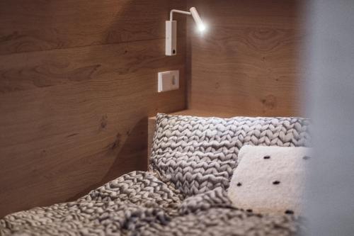 1 dormitorio con 1 cama con luz en la pared en Rousa little guesthouse Cosy Plus, en Rasun di Sopra