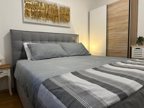 a bedroom with a bed with a striped blanket at Apartmani Roko in Biograd na Moru