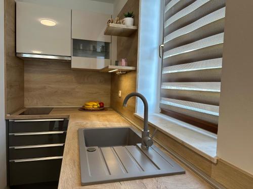 a kitchen with a sink and a window at Apartmani Roko in Biograd na Moru