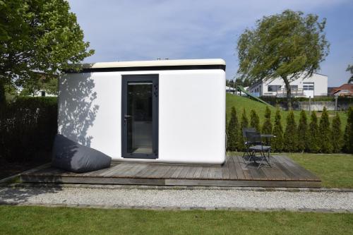 にあるTiny House in ruhiger Lageの木製デッキ上の小さな白い小さな家