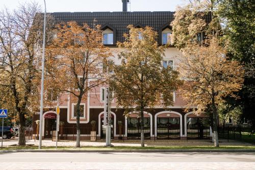 un edificio su una strada con alberi di fronte di Non-stop hotel a Boryspilʼ