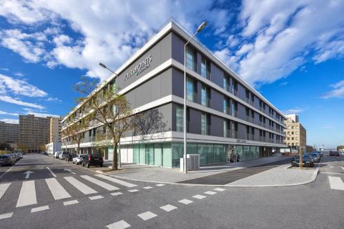 a building on a street with cars parked in front of it at Four Points by Sheraton Matosinhos in Matosinhos