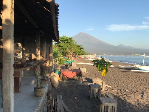 una spiaggia con un edificio e una spiaggia con una montagna di Tudes Homestay ad Amed