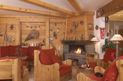 - un salon avec une cheminée et des chaises rouges dans l'établissement Edelweiss, à Samoëns