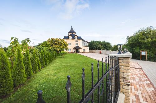 una cerca frente a una casa con un patio en Navigator, en Palić